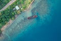 Abandoned broken sunken old ship that ran aground. Drone view. Tropical coast of Sanma, Vanuatu