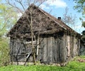 An abandoned broken wooden house with boarded-up windows in a forgotten village Royalty Free Stock Photo