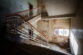 Abandoned building creepy dark moody staircase in dilapidated run down old deserted hospital school ruin with a single empty chair