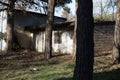 Abandoned burned old house in winter at sunset in forest. Abandoned hunting lodge in the warm rays of the sun in the middle of the Royalty Free Stock Photo