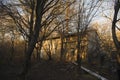 Abandoned burned old house in winter at sunset in forest. Abandoned hunting lodge in the warm rays of the sun in the middle of the Royalty Free Stock Photo