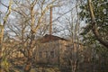 Abandoned burned old house in winter at sunset in forest. Abandoned hunting lodge in the warm rays of the sun in the middle of the Royalty Free Stock Photo