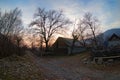 Abandoned burned old house in winter at sunset in forest. Abandoned hunting lodge in the warm rays of the sun in the middle of the Royalty Free Stock Photo