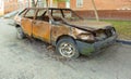 Abandoned burned passenger car near the apartment building. Russia