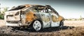 Abandoned burnt car at isolated field Royalty Free Stock Photo