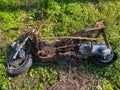 Abandoned burnt motor bike in the middle of a forest hiking trail.