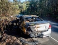 Abandoned burnt out car at the road side rear end image Royalty Free Stock Photo