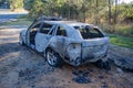 Abandoned burnt out car station wagon rear left side Royalty Free Stock Photo