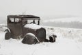 Abandoned car covered in snow and put out to pasture