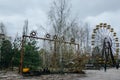 Abandoned carousel and abandoned ferris at an amusement park in the center of the city of Pripyat, the Chernobyl disaster,