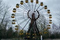 Abandoned carousel and abandoned ferris at an amusement park in the center of the city of Pripyat, the Chernobyl disaster,