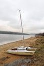 Abandoned catamaran boat standing on the sandy beach Royalty Free Stock Photo