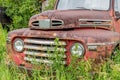 Abandoned red pickup truck in tall grass on Canadian prairies Royalty Free Stock Photo