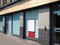 Abandoned closed high street bank or store front with boarded up and covered windows