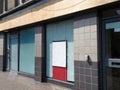 Abandoned closed high street bank or store front with boarded up and covered windows