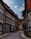 Abandoned cobblestone alleyway between two towering buildings