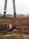 Abandoned couch on a field against a power tower