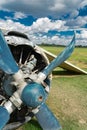 Abandoned crashed old soviet Antonov AN-2 airplane with bended blue prop on grass