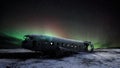 Abandoned DC plane in Iceland with aurora northern light and star background Royalty Free Stock Photo
