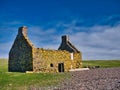 An abandoned, derelict croft or farm house with no roof on a pebble beach at Stenness, Northmavine in  Shetland, Scotland, UK. Royalty Free Stock Photo