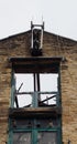 Abandoned derelict industrial warehouse building with missing roof and broken windows