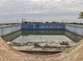 An abandoned and derelict Swimming Pool just off the promenade in Sao Tome, viewed through one of its round windows. Royalty Free Stock Photo