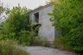 Abandoned dilapidated old brick building, broken glass from wooden frames, with ground overgrown with grass Royalty Free Stock Photo