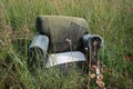 ABANDONED DISTORTED UPHOLSTERED ARM CHAIR IN A FIELD Royalty Free Stock Photo