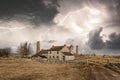 Abandoned empty rural stone cottage in Peak District near to old deserted ancient mine workings with dramatic big lightning storm. Royalty Free Stock Photo