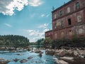 Abandoned factory on the water edge. old building on the rocky river. brown brick wall Royalty Free Stock Photo