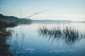 The abandoned feeder rod in a summer day on the river Royalty Free Stock Photo
