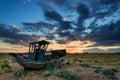 Abandoned fishing boat on beach landscape at sunset Royalty Free Stock Photo