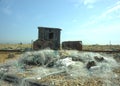 Abandoned Fishing huts and nets on beach.