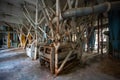 Abandoned flour milling factory. Old rusty roller mill equipment with pipeline