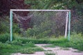 Abandoned football field, goal with a torn net in a vacant lot Royalty Free Stock Photo