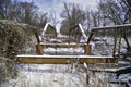 A long abandoned bridge rusts under the winter snow and dreary sky