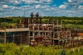Abandoned forgotten ruined chemical plant overgrown by plants and trees, aerial view
