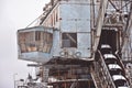 abandoned giant bucket wheel excavator stands in a field in winter