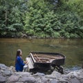 Abandoned gran piano, rundown piano by a river bank Vilnia river in Uzupis artists quarter in Vilnius, Lithuania, bohemian Royalty Free Stock Photo