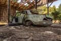 Abandoned green car in old ruined garage