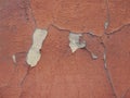 Old peeling red terracotta pink plaster on a cracked rough, scratched uneven concrete stone wall. Royalty Free Stock Photo