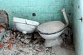 Abandoned house bathroom with broken toilet, sink and tiles