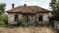 Abandoned house with damaged roof and overgrown vegetation