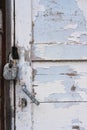 Abandoned house door texture background. Locked wooden entrance with old fashion metal padlock. Blue, white peeled off paint