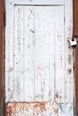 Abandoned house door texture background. Locked wooden entrance with old fashion padlock. Blue, white and brown peeled off paint