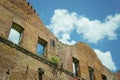 Abandoned house, ruined wall against the blue sky with clouds.