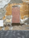 Dilapidated wall of an abandoned house with a large window bricked up to prevent the entry of squatters, ruin texture Royalty Free Stock Photo