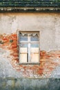 Abandoned house window with peeling plaster and exposed brick Royalty Free Stock Photo