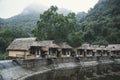 Abandoned houses of an old hotel in the woods. Straw, bamboo, thatch-roof cottage resort delivered in line with mountains as a Royalty Free Stock Photo