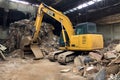 Abandoned industrial building site with a yellow excavator in the foreground. Generative AI Royalty Free Stock Photo